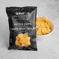 Bag of Snake River Farms kettle chips cooked in Wagyu beef tallow with a bowl of chips on a gray background