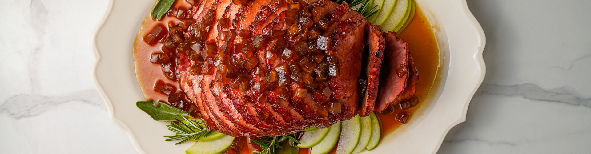 Sliced ham with apples and herbs on a decorative plate