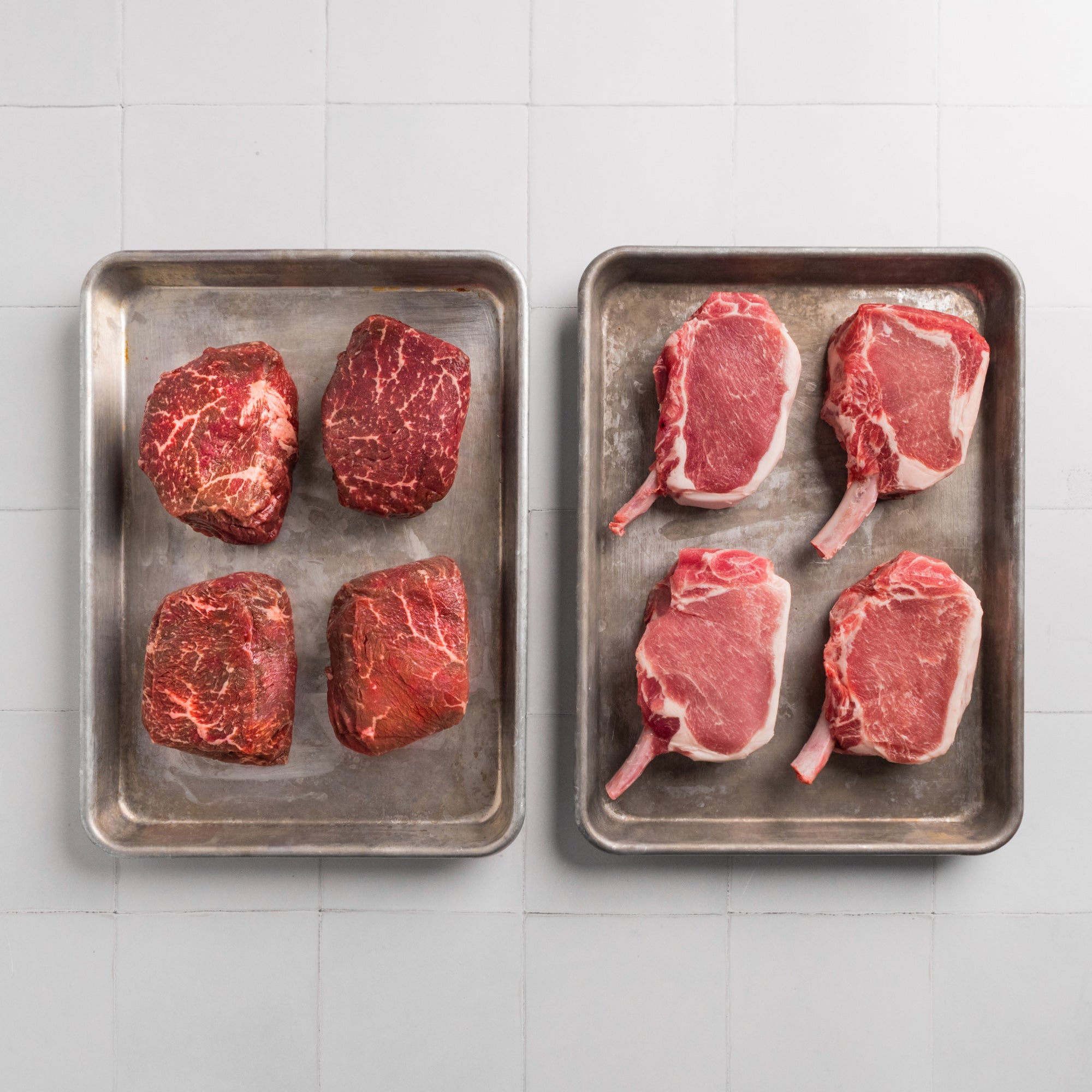 A collection of fresh meats including American Wagyu steaks and Kurobuta pork chops.