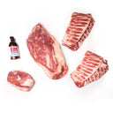 Raw meat cuts with a bottle of sauce on a white background