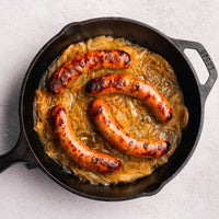 bacon bratwurst cooked in cast iron with onions