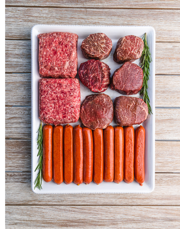 Platter of ground beef, sausages, and rosemary on a wooden surface