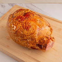 whole bone-in ham on cutting board 