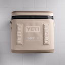 Beige cooler bag with YETI logo on a light gray background