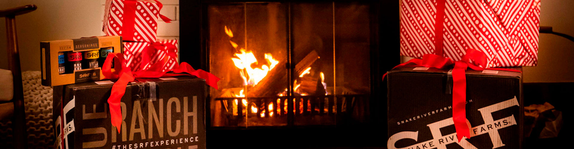 Gift boxes with red ribbons in front of a fireplace