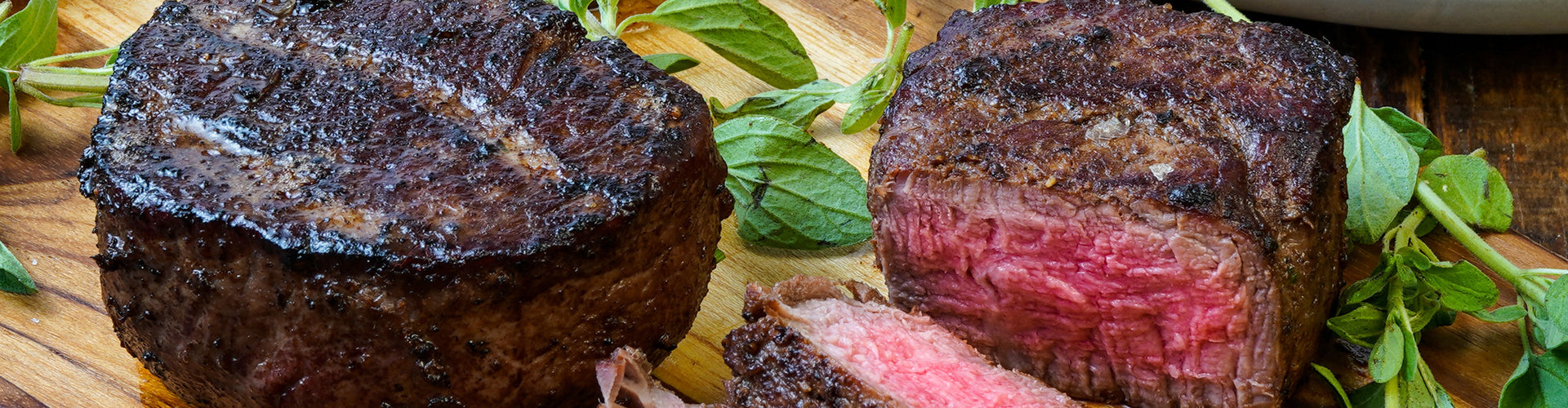 Sliced steak with a focus on texture and color on a wooden board.