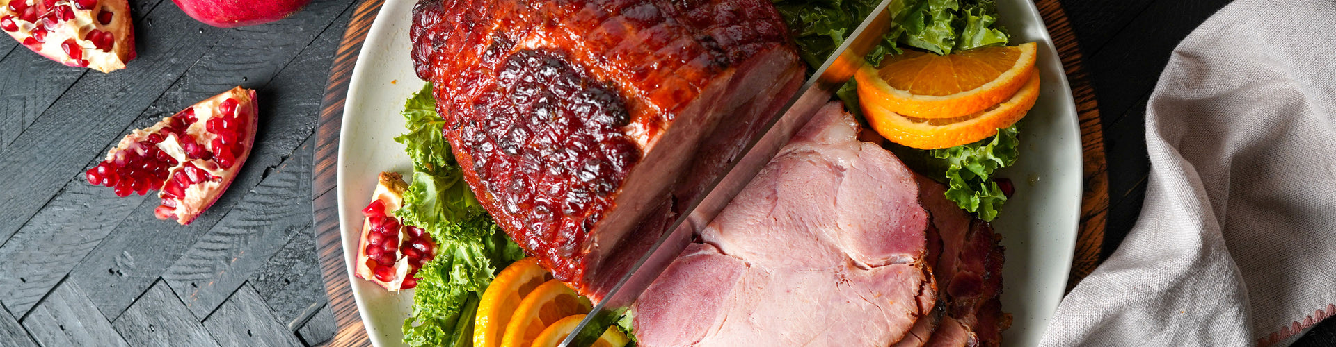 Plated ham with garnishes on a wooden table