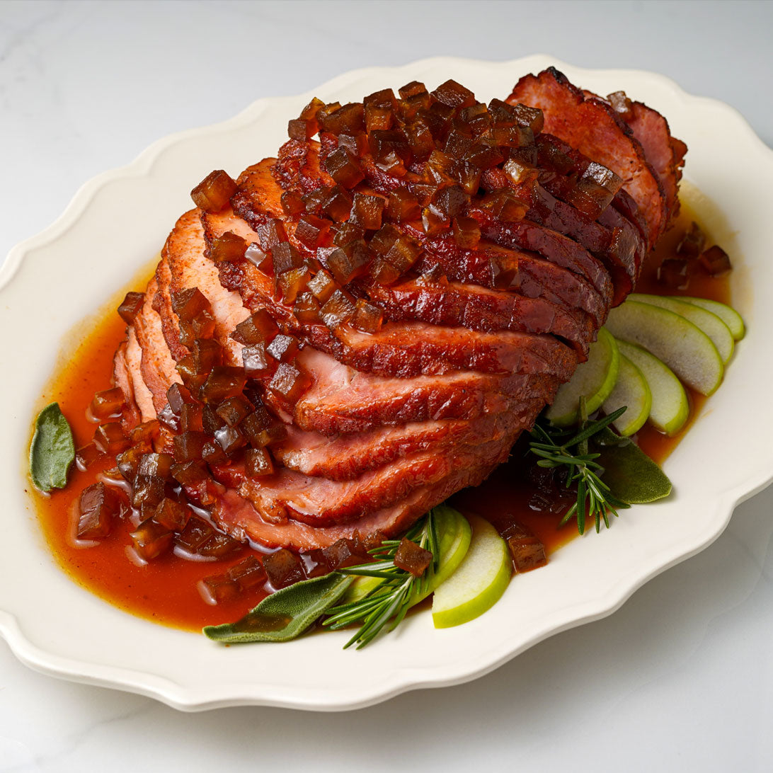 Sliced ham with apple chutney on a white plate