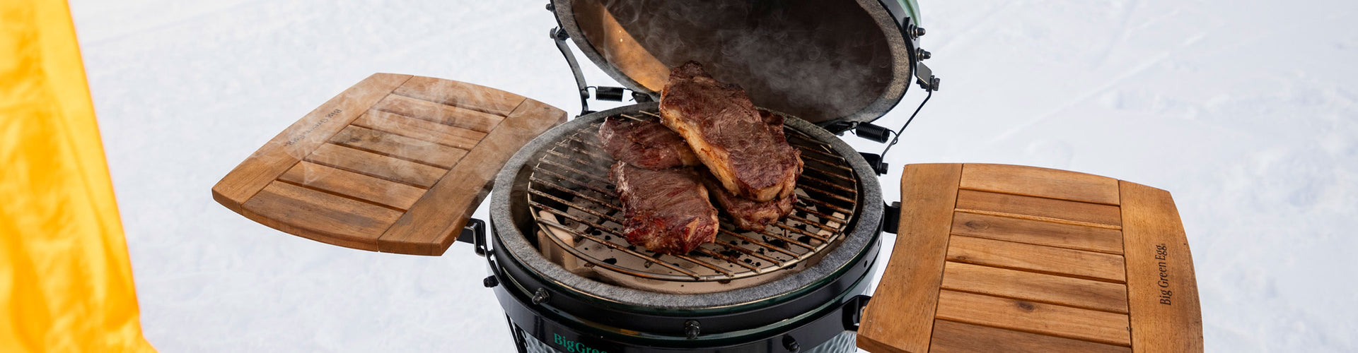 Barbecue grill with steaks on a snowy background